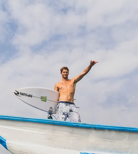 Crosby Colapinto standing on a boat throwing a shakka