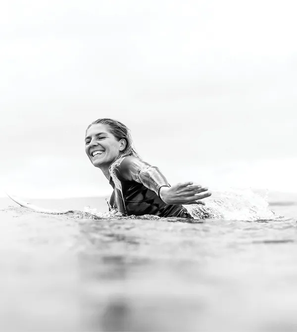 Black and white image of Stephanie Gilmore paddling out